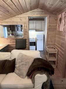 ein Wohnzimmer mit einer Couch in einem winzigen Haus in der Unterkunft Bäckstugan in Sälen