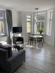 a living room with a couch and a table and chairs at Apartmánový dům Jánský sen in Janske Lazne
