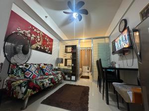 ein Wohnzimmer mit einem Sofa und einem Tisch mit einem Ventilator in der Unterkunft Staycation for you at Casa Amara near MOA in Manila