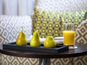 ein Tablett mit Birnen und einem Glas Orangensaft in der Unterkunft Warwick Hotel Jeddah in Dschidda