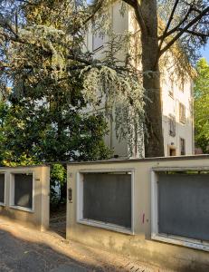 un edificio blanco con tres ventanas y un árbol en Appartamento Pannaggi, en Bolonia