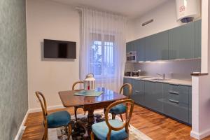 cocina con mesa de madera, sillas y fregadero en Appartamento Pannaggi, en Bolonia