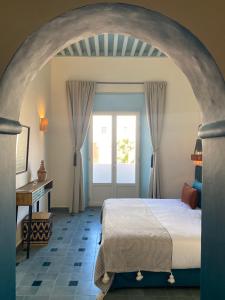 a bedroom with an archway with a bed and a desk at Le Palazzo in Essaouira