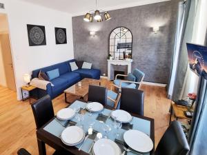 a living room with a table and a blue couch at "Le Nomad" by EnjoyNice, luxury central apartment with airco in Nice +12 photos