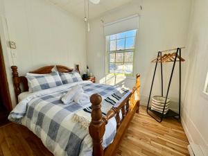 a bedroom with a bed with a blue and white blanket at Fireplace beach access pet friendly in Sainte-Agathe-des-Monts