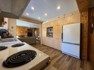 a kitchen with a white stove and a refrigerator at Fireplace beach access pet friendly in Sainte-Agathe-des-Monts