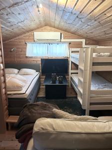 a room with three bunk beds in a cabin at Bäckstugan in Sälen