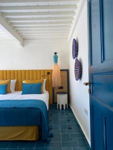 a bedroom with a bed and a blue door at Le Palazzo in Essaouira