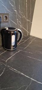 a black coffee cup sitting on a counter at Studijos tipo butas šalia parko in Kretinga