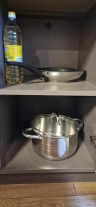 a metal pot on a shelf with a bottle of water at Studijos tipo butas šalia parko in Kretinga