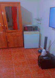 a kitchen with a microwave and a refrigerator at Welcome to Hilltop Villa in Dakar