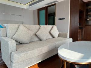 XI AN JIU DIAN Hotel في سيهانوكفيل: غرفة معيشة مع أريكة وطاولة