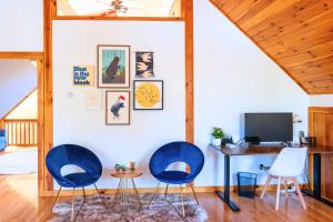 Habitación con 2 sillas azules y escritorio. en Lake, Kayaks & Sauna - Family & Wellness en Otis