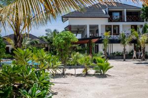 a house on the beach with palm trees at Baobab Bungalows in Jambiani