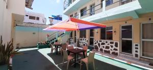 patio con tavolo e ombrellone su un edificio di HISTORICO HOSTAL ELIZABETH a Puerto Ayora