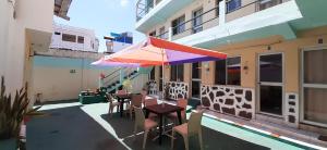 un patio con una mesa y una sombrilla en un edificio en HISTORICO HOSTAL ELIZABETH, en Puerto Ayora