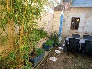 a patio with a table and chairs and plants at Gîte avec vue sur l'Indre in Artannes-sur-Indre