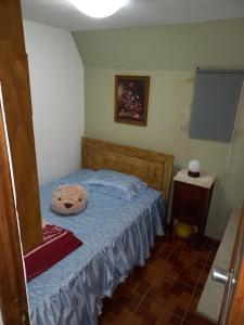 a bedroom with a bed with a hat on it at Casa Serrana in Penhas da Saúde