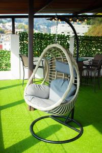 a white wicker chair sitting on a balcony at Apto Vista Hermosa con terraza ajardinada privada in Sololá