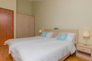 - une chambre avec un grand lit blanc et des oreillers bleus dans l'établissement Nala Apartman 9, à Selce