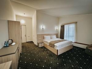 ein Hotelzimmer mit einem Bett und einem Fenster in der Unterkunft Colette Hotel in Yerevan