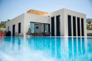 a house with a swimming pool in front of it at Zita Fidar in Al Fīdār