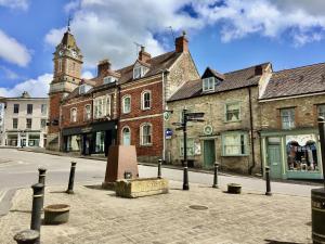 a city street with buildings and a clock tower at Two Bedroom Apartment in South Somerset in Wincanton