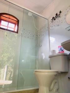 a bathroom with a toilet and a glass shower at Camping Mill Off Adventure in Paraty