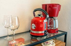 a red coffee maker and two wine glasses on a shelf at 4B Stay - Best Budget Boutique Boardinghouse in Helsinki