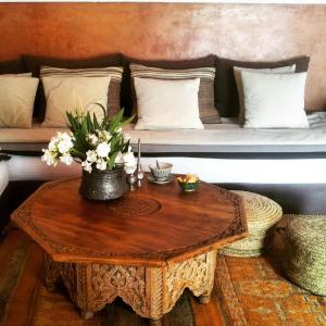 a living room with a couch and a table with flowers at Dar Al Manar in El Jadida