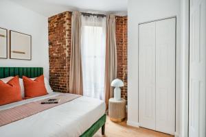 1 dormitorio con cama y pared de ladrillo en 153-5A Charming 2BR LES W D en Nueva York