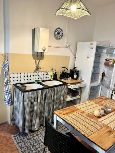 cocina con mesa y nevera en Slunný byt s krásným výhledem, en Nové Město nad Metují