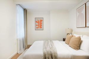 Un dormitorio blanco con una cama grande y una ventana en 76-1D Brand New 4BR 3BTH UES Doorman Gym, en Nueva York