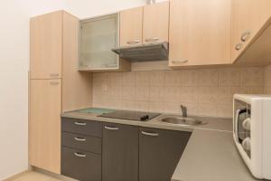 a small kitchen with a sink and a microwave at Simba Apartman 59 in Selce