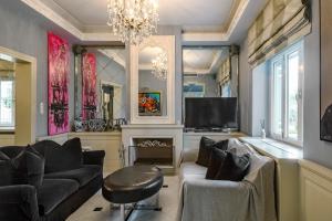 uma sala de estar com dois sofás e uma televisão em Le Petit Palais em Atenas