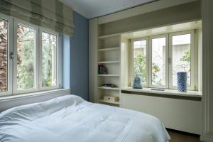 Schlafzimmer mit blauen Wänden und einem Bett mit Fenstern in der Unterkunft Le Petit Palais in Athen