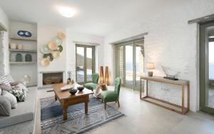 a living room with a table and a fireplace at Triad Villas in Ioulis
