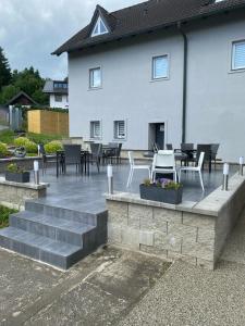 a patio with tables and chairs in front of a house at Apartmán HARMONY - Lipno nad Vltavou in Lipno nad Vltavou