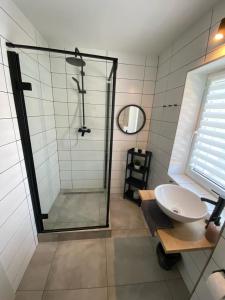 y baño con ducha acristalada y lavamanos. en Apartmán HARMONY - Lipno nad Vltavou, en Lipno nad Vltavou