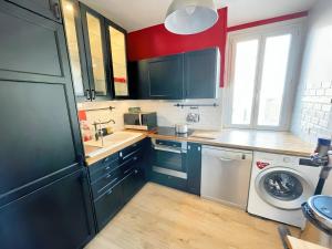 eine Küche mit blauen Schränken und einer Waschmaschine in der Unterkunft 3P cosy et lumineux proche de La Défense et Paris in La Garenne-Colombes