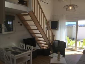 a living room with a staircase with a couch and a table at L’Echappée Belle in Saint-Jean-de-Fos