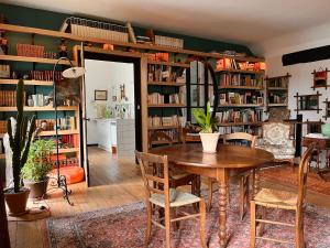 ein Esszimmer mit einem Tisch und Bücherregalen in der Unterkunft les loges du chaudron in La Chapelle-aux-Choux