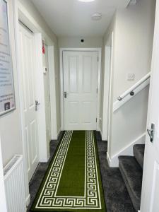 un pasillo con un suelo verde delante de una puerta en Hesed Home en Edimburgo