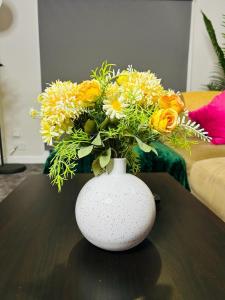 a white vase with a bouquet of flowers on a table at Hesed Home in Edinburgh