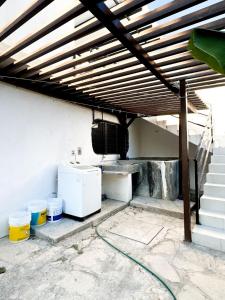patio z drewnianym dachem, lodówką i schodami w obiekcie Apartamento pichones w mieście Comitán de Domínguez