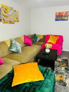 a living room with a couch with colorful pillows at Hesed Home in Edinburgh