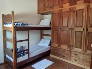 サン・ジョアン・デル・レイにあるAconchego Mineiroの二段ベッド2台とキャビネットが備わる客室です。