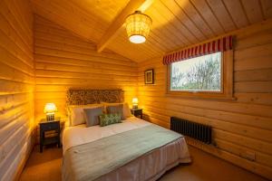 ein Schlafzimmer mit einem Bett in einem Blockhaus in der Unterkunft The Cabin in Marlow