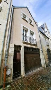 a building with two garage doors and a balcony at Charmante maison de ville centre historique Tours 5p in Tours