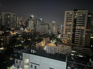 a city skyline at night with tall buildings at Omni Tower Sukhumvit Soi 4 Direct Rooms in Bangkok